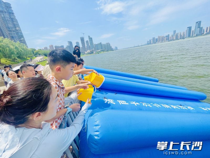 亲子家庭参与放流珍稀胭脂鱼。长沙晚报全媒体记者 李卓 摄