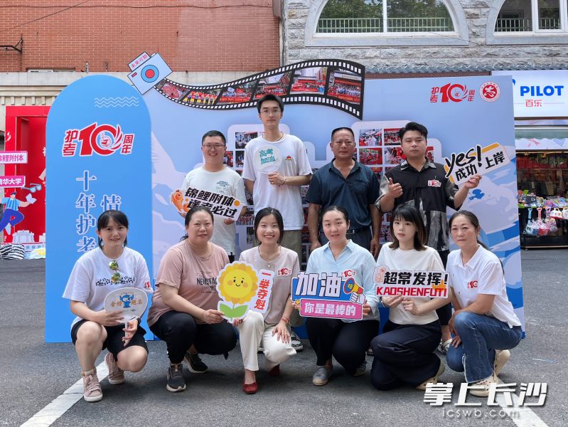 打卡墙前，十年前第一批护考志愿者和社区工作人员、家长合影打卡。均为长沙晚报全媒体记者 李卓 摄