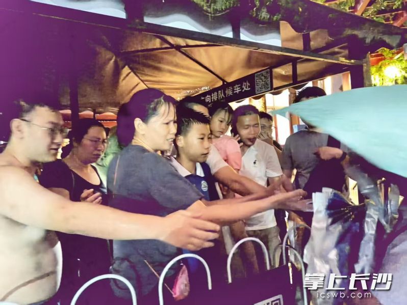 景区工作人员为游客分发雨具。景区供图
