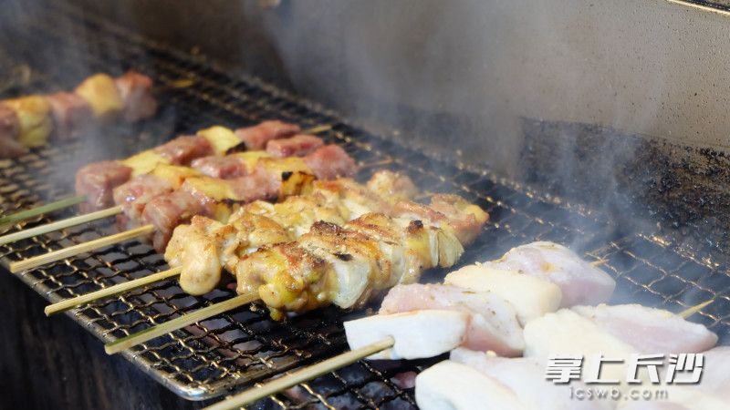 炭火正旺，各种肉串儿在烤架上滋滋作响，烧烤味香飘四溢。