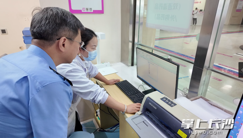 检查人员在查看医院药品台账。长沙晚报全媒体记者 周辉霞 摄
