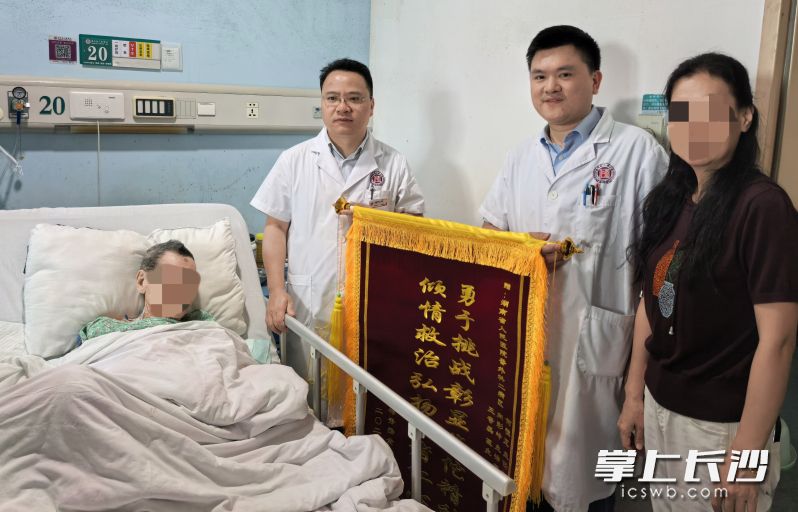 患者家属将一面写有“勇于挑战彰显华佗精神，倾情救治弘扬医者仁心”的锦旗送给湖南省人民医院胃肠外科何恒正教授团队。长沙晚报通讯员 向彩岭 供图
