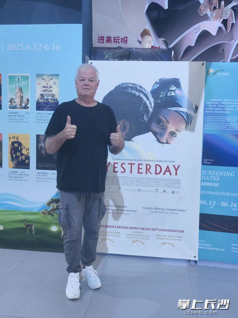 导演达雷尔・鲁特与自己作品的展板合影。长沙晚报全媒体记者 宁莎鸥 摄
