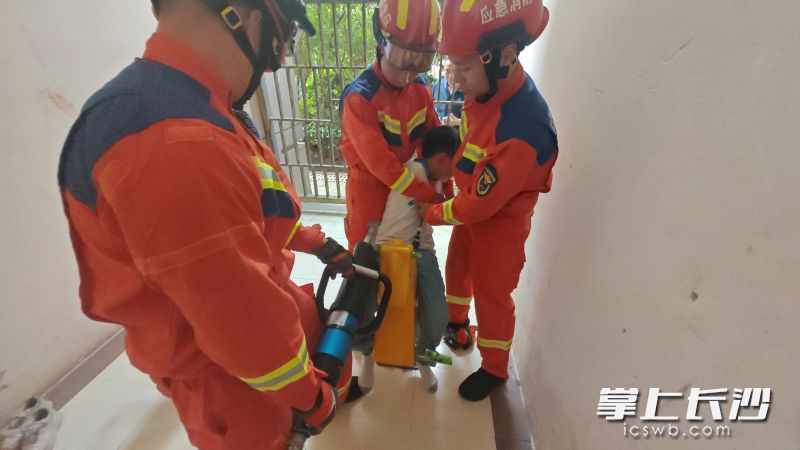 消防队员帮助小男孩脱困。 长沙晚报通讯员 杨慧 摄