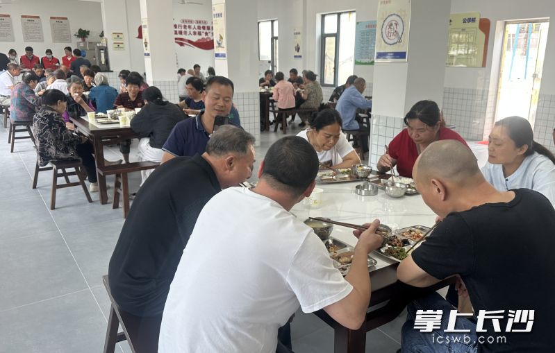 老人们开心地享受着社区提供的爱心餐。