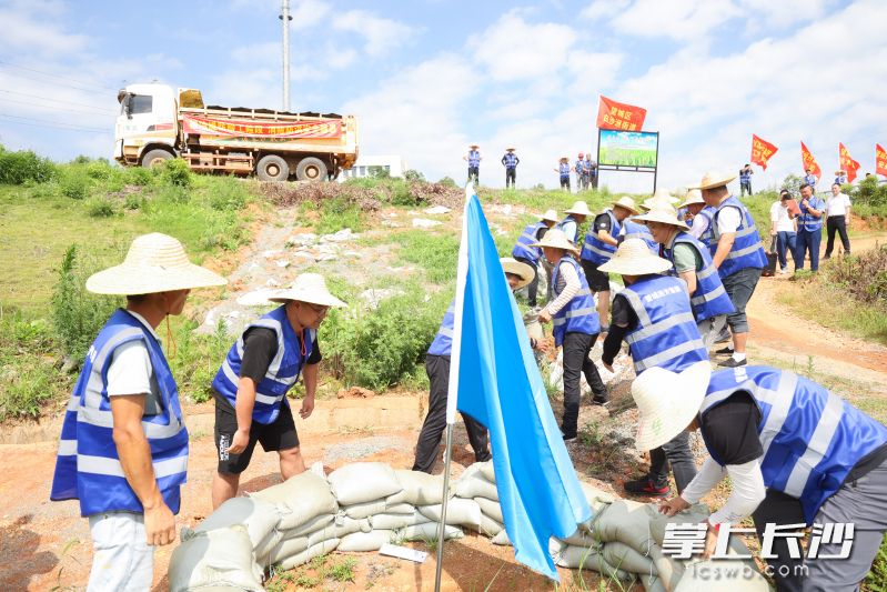 现场工作人员密切配合,有序开展沙袋搬运和堤坝加固等工作。 现场工作人员密切配合,有序开展沙袋搬运和堤坝加固等工作。