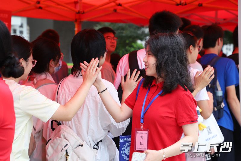 在长沙市一中双语实验学校，穿着红衣的老师跟进考场的学生击掌加油。 长沙晚报通讯员 谢雨娜 摄