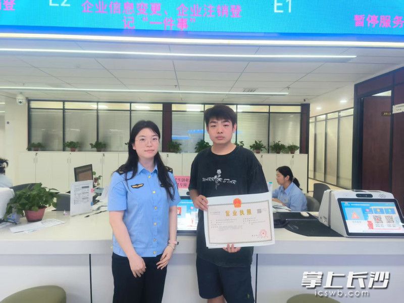 湖南体育职业学院大一新生陈文杰从工作人员手中接过崭新的营业执照。  均为长沙晚报全媒体记者周游、通讯员符雅梅摄
