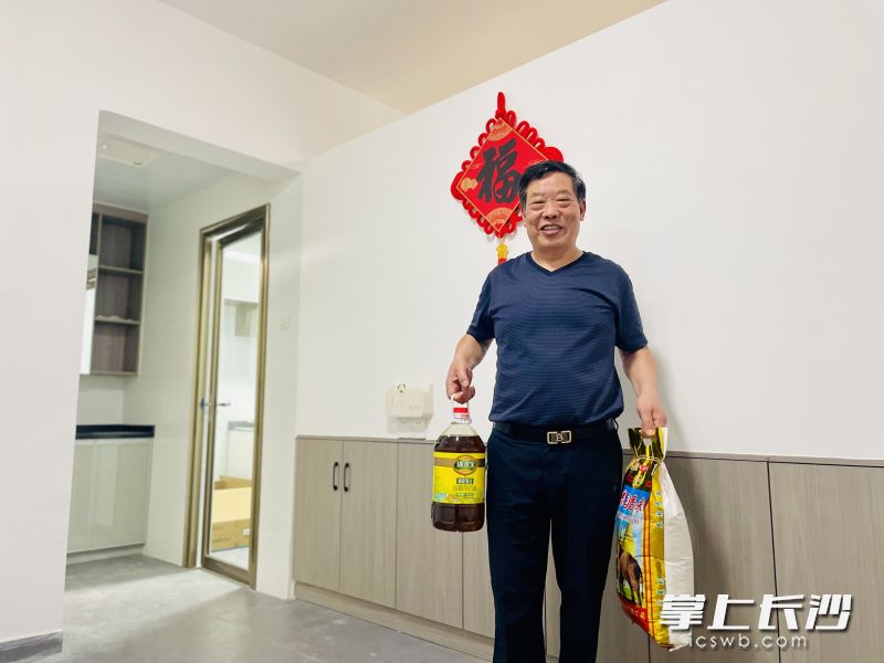 居民拎着礼包住进装修一新的新房。 居民拎着礼包住进装修一新的新房。