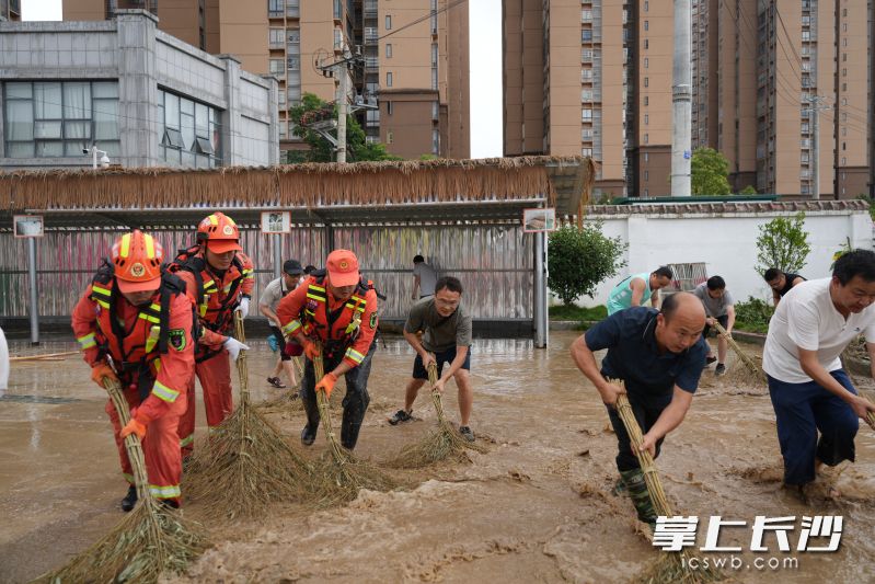 来自长沙的消防员和和当地群众一起在龙山望城幼儿园清淤。 均为长沙晚报通讯员冯运文供图