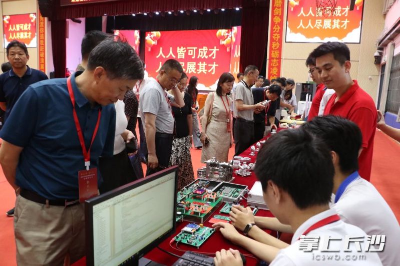 电子信息社团在电路板上娴熟地展示着专利作品。