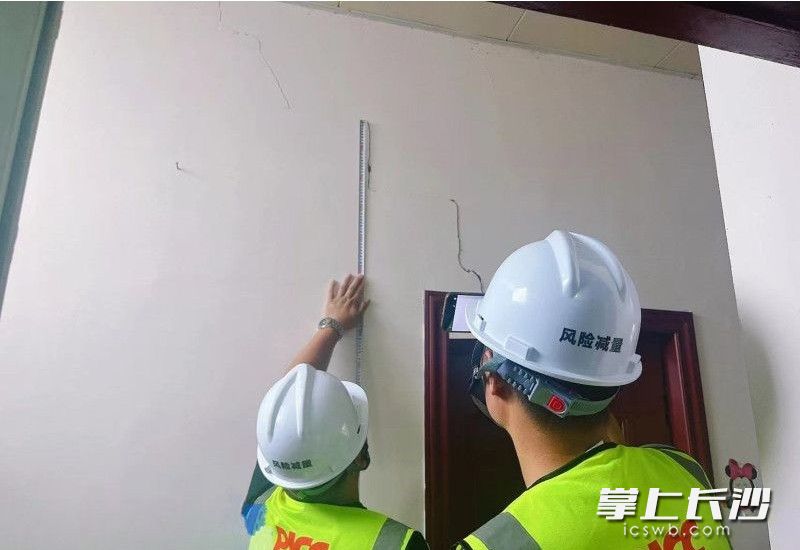 工作人员正在丈量裂缝长度。受访者供图
