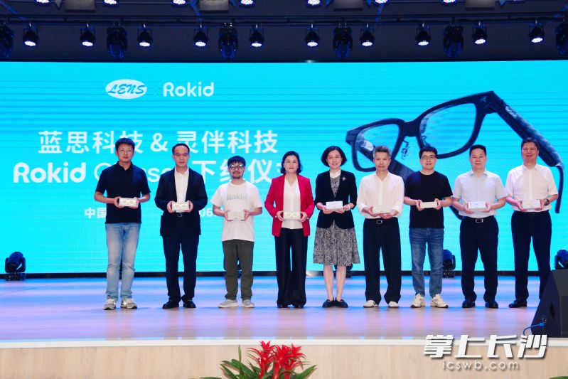 在为首批下线产品签名仪式上,Rokid CEO祝铭明(左三)戴上了湖南造的Rokid Glasses。均由蓝思科技供图 在为首批下线产品签名仪式上,Rokid CEO祝铭明(左三)戴上了湖南造的Rokid Glasses。均由蓝思科技供图