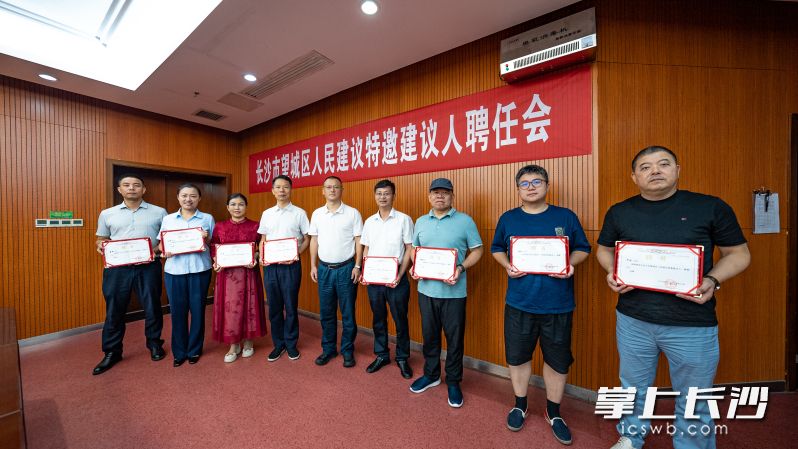 人民建议特邀建议人接过聘书。