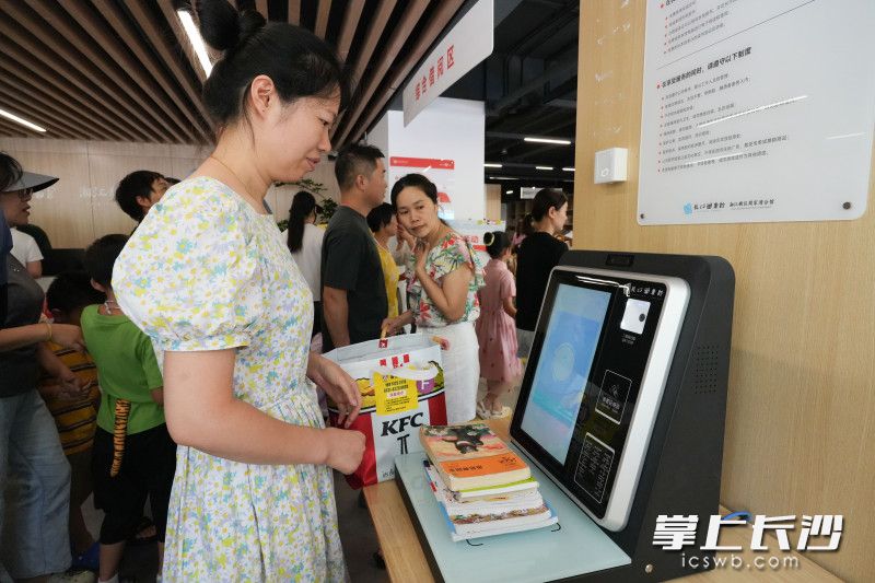 一位家长正在自助借阅书籍。