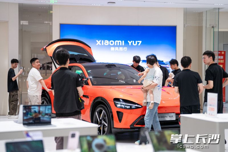 门店内挤满了前来看车试驾的顾客，YU7展车被围得水泄不通。