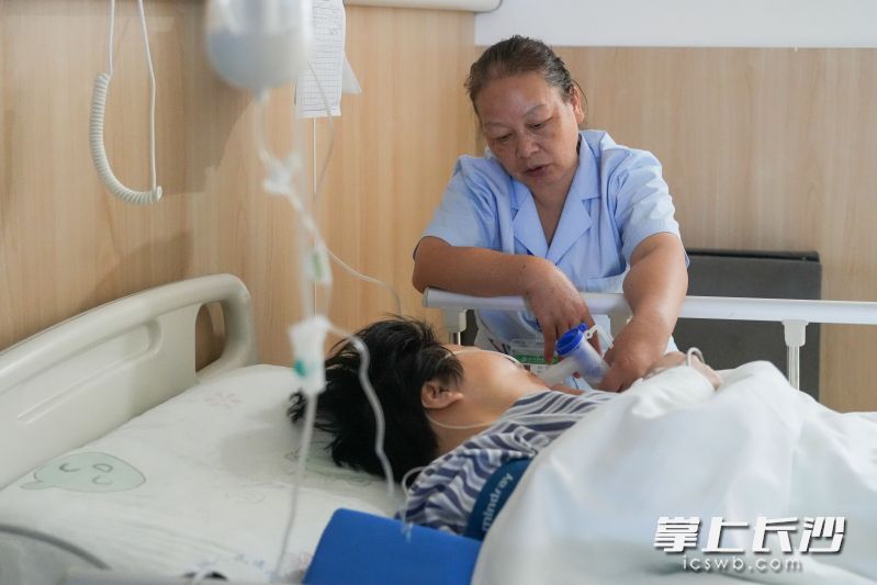护工在照护患者。均为长沙晚报全媒体记者 邹麟 摄