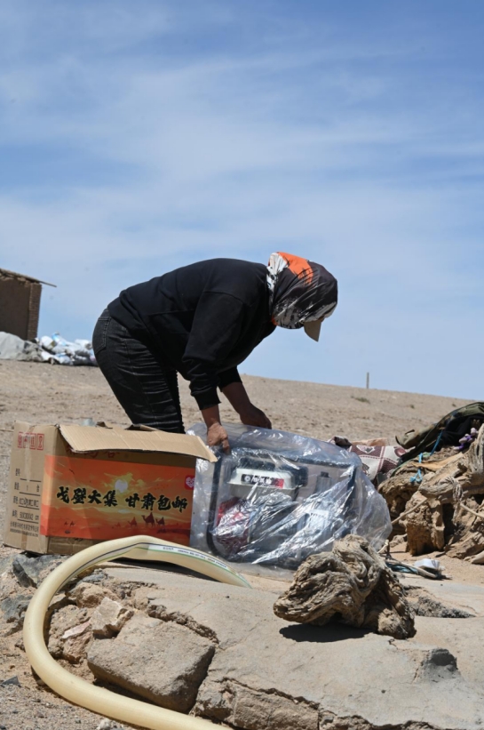 孟根正拆开从拼多多上网购回来的发电机。通讯员 陈蕾 摄