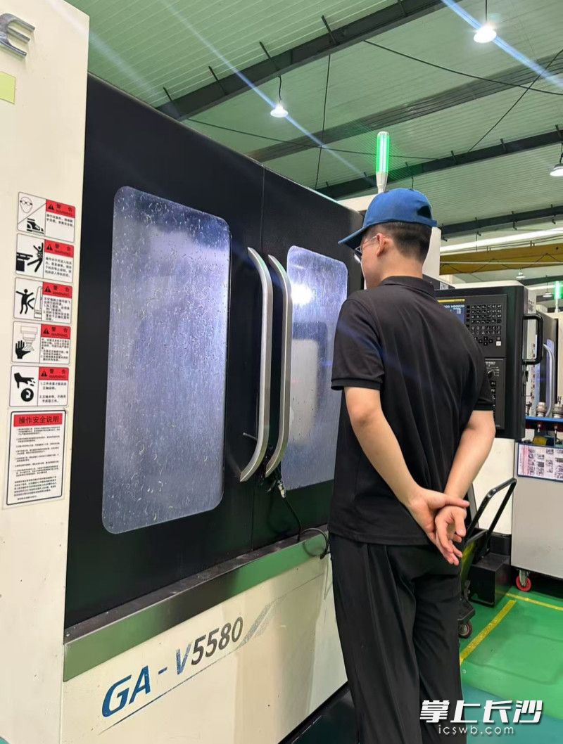 黄忠覃全神贯注盯着正在车窗内加工的精密部件。