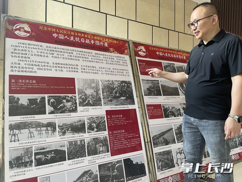 长沙市抗战文化研究会秘书长唐智轩在展板前介绍长沙会战的历史。 均为长沙晚报全媒体记者李广军摄