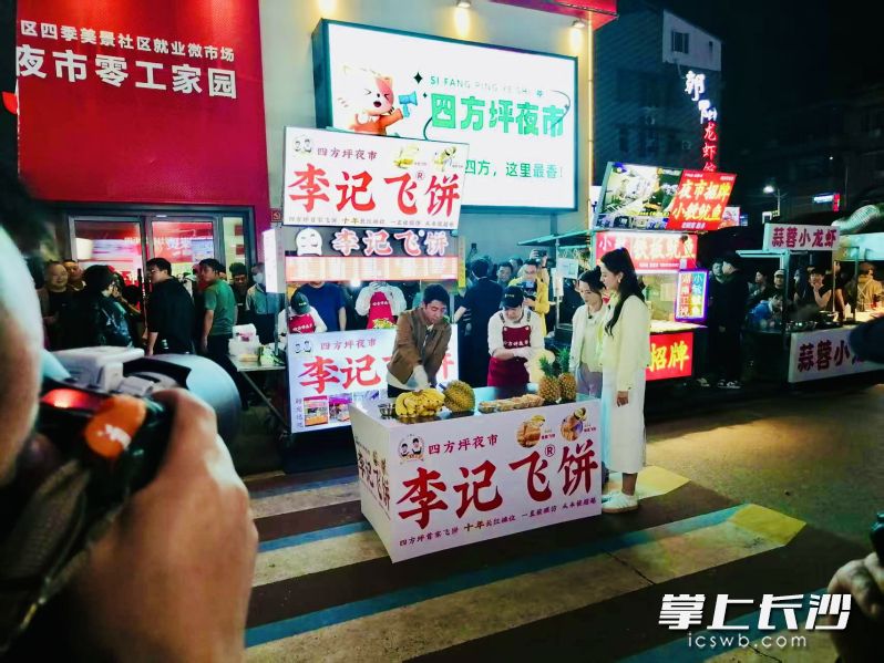 撒贝宁和四方坪夜市摊主小哥一起玩转甩饼。均为长沙晚报通讯员 郭丹 供图