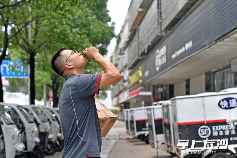 7日最高气温达37℃，炎炎烈日下，胡林海喝下一小瓶藿香正气水后接着送件。 均为长沙晚报全媒体记者王志伟、实习生傅千寻摄