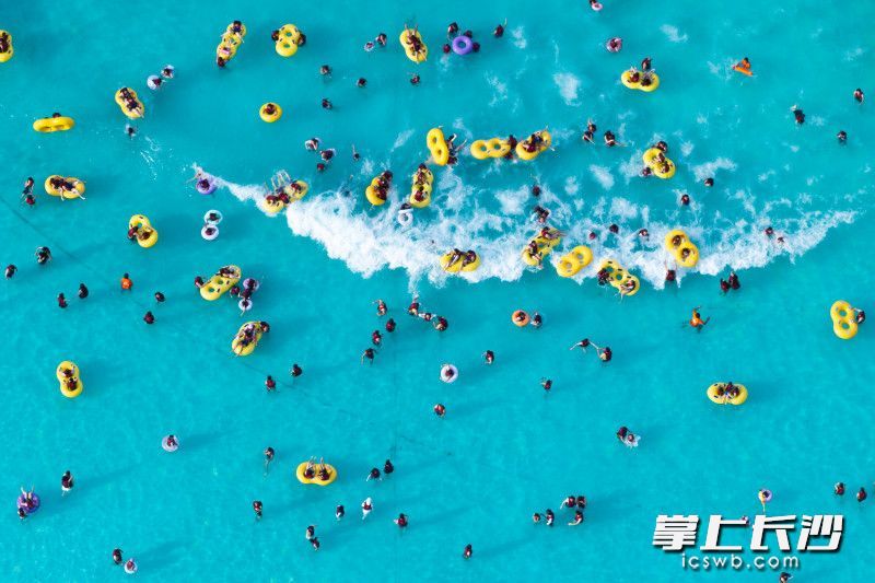 7月9日下午，位于长沙园林生态园内的乐水魔方水世界造浪池里，一波波模拟海浪席卷而来，大人小孩们在水中欢呼着、跳跃着，任凭清凉的水花溅满全身，将夏日的燥热瞬间驱散。 均为长沙晚报全媒体记者黄启晴、王志伟摄