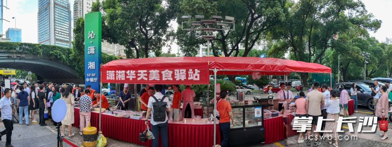 长沙潇湘华天大酒店门口，一盒盒精致的卤味、点心整齐地码放在摊位上