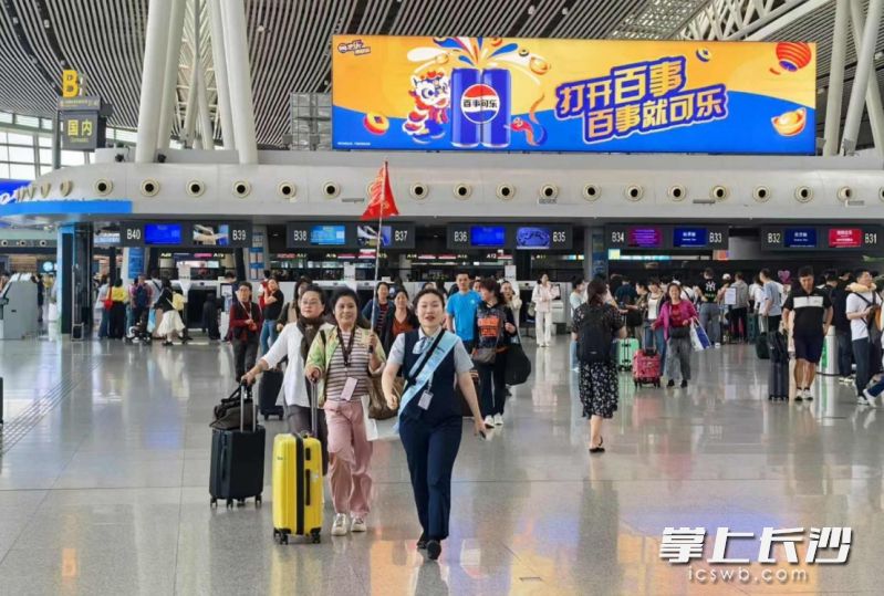 在长沙机场，团队管家正引领团队旅客领取已提前打印的登机牌。