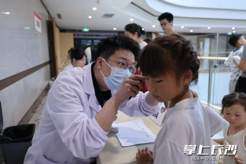 在免费义诊区，医生们正为孩子进行检查。