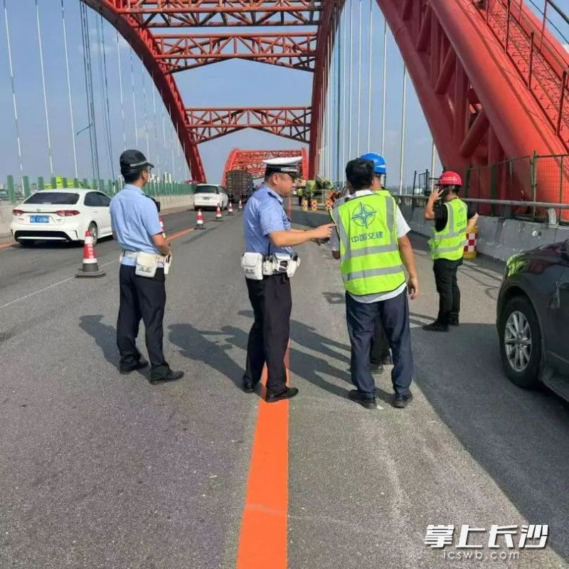 中队长陈东和队友烈日下保持大桥畅通。