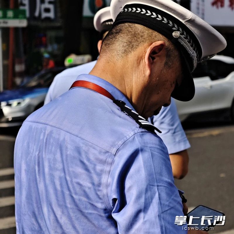 烈日下值守的交警满是汗水。通讯员 张旭 摄