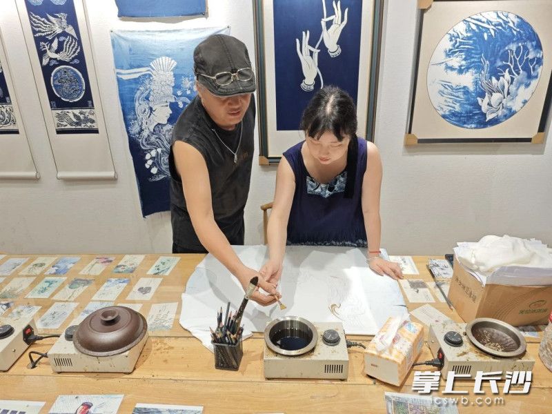 何方蓉向王曜老师学习蜡染技术。