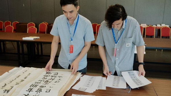 评委们或凝神细察，或交流探讨，在字里行间精准把握作品的艺术水准。