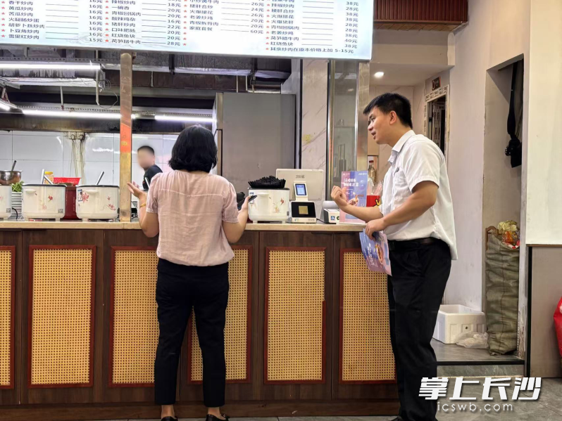 粉店收银台前，银行员工正熟练地指导顾客核销优惠券、解答手机支付问题。 均为通讯员供图