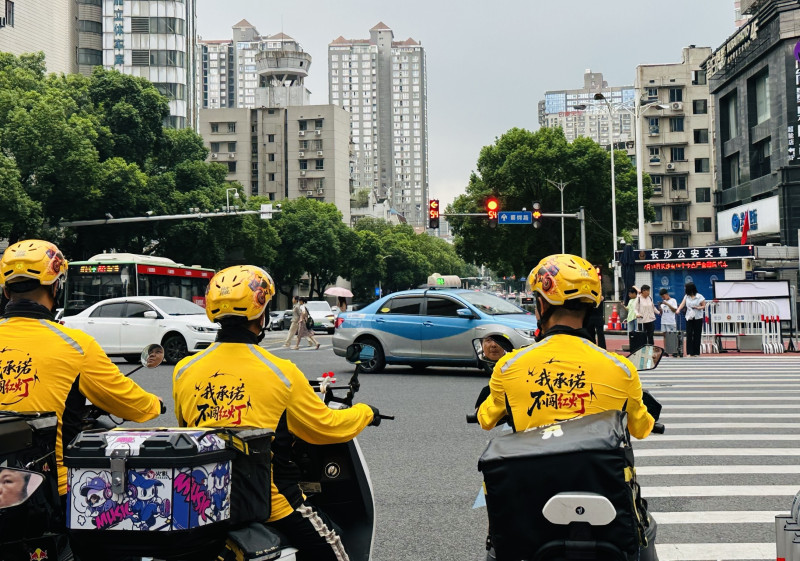 在长沙街头，美团外卖骑手正在等红灯。长沙晚报通讯员 伍一一 摄