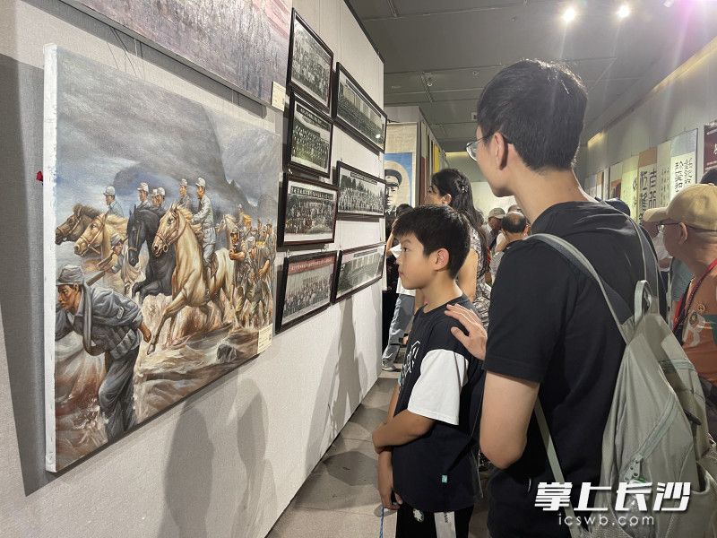 “纪念中国人民抗日战争暨世界反法西斯战争胜利80周年书画展”现场，观展的少年。长沙晚报全媒体记者 李广军 摄