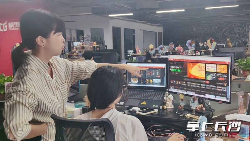 董艳与同事沟通CG模型网相关工作。长沙晚报全媒体记者 匡小娟 摄。
