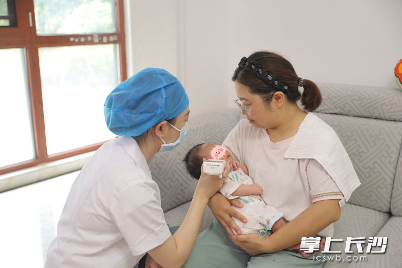 在陈女士家中，护士正在为宝宝测黄疸。 医院供图