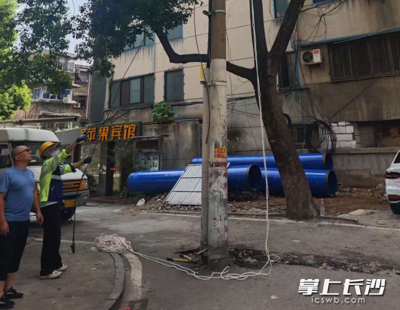 芙蓉区火车站社区朝阳一村小区23栋和29栋之间的干道上，一根电线杆矗立了二三十年。 均为长沙晚报全媒体记者陈焕明 通讯员李少校摄