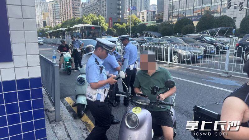 开福交警在路面整治骑电动自行车不戴头盔的违法行为。通讯员 赵东平 摄
