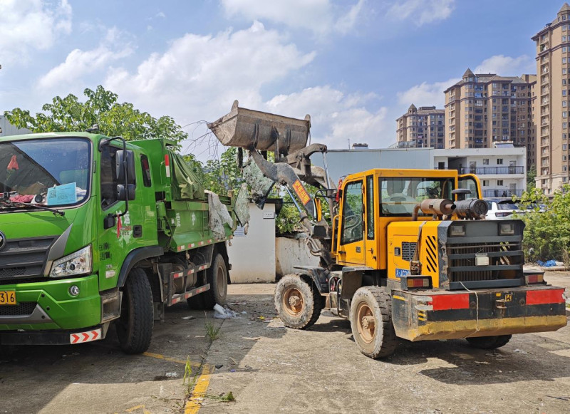 物业通过铲车、垃圾清运车设备清理建筑垃圾。