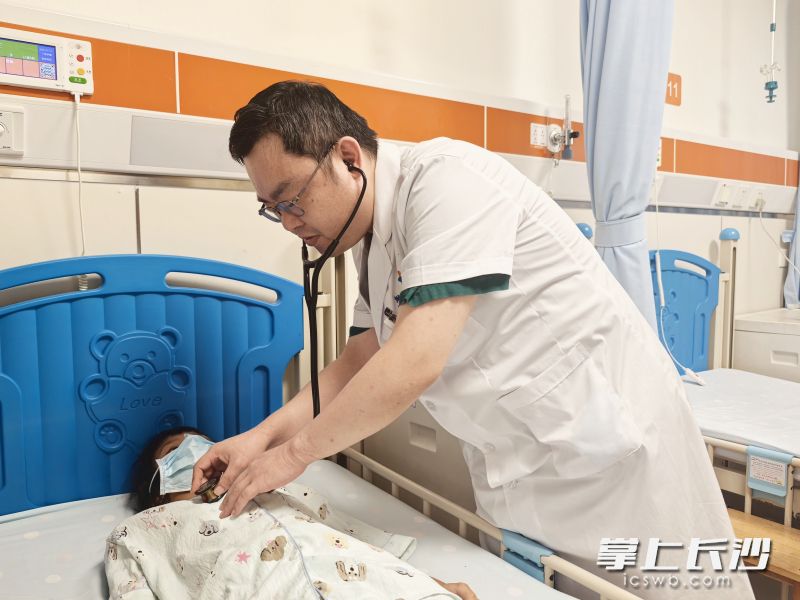 湖南省儿童医院心胸外科主任医师罗金文为小艳检查。医院供图