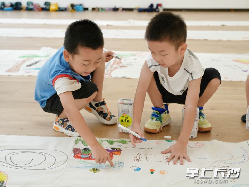 两个孩子交流各自的画画心得。 均为芒果美术馆供图