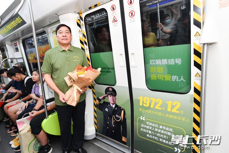 今年73岁的退伍老兵徐佐林与自己的照片合影留念。