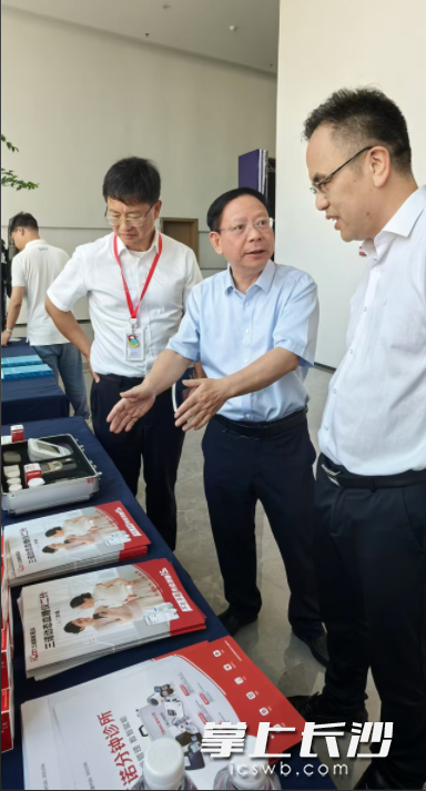 联盟相关专家在医疗器械行业展示台前进行慢性病防控的智能化数据传输探讨。