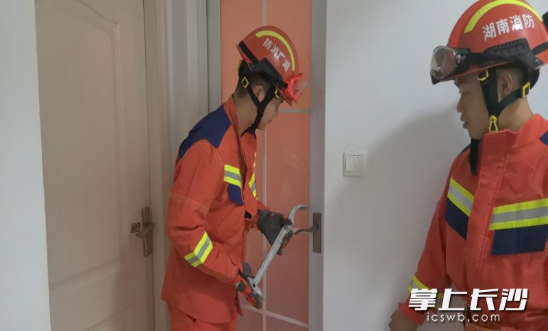 消防在破门救援。 均为长沙晚报通讯员 龙伟杰 供图