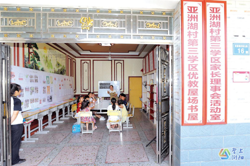 优教屋场内，志愿者正带着孩子们朗读英文。