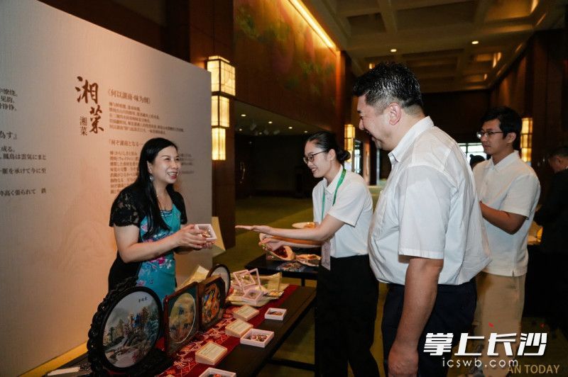 国家级非遗代表性传承人江再红向参观者介绍湘绣作品。