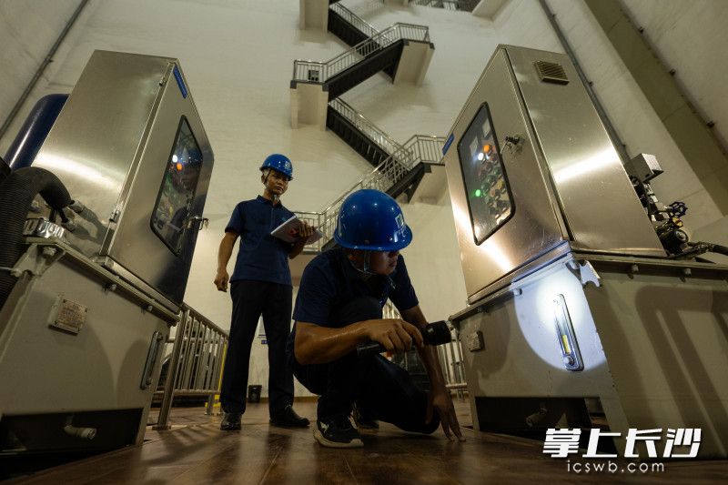 周栋宇和汤辉检查设备运转情况。